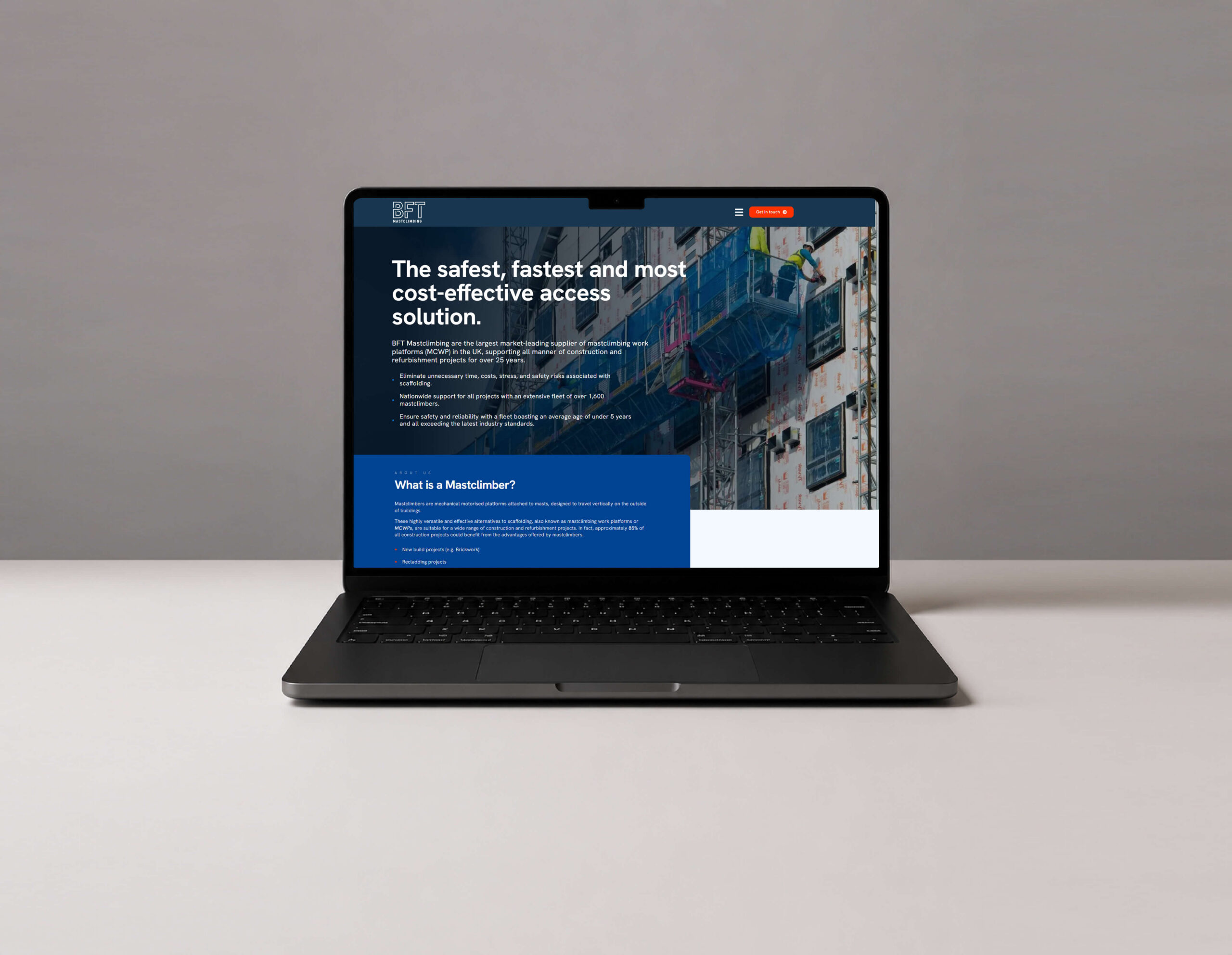 Laptop screen showing BFT Mastclimbing website homepage with construction platform image