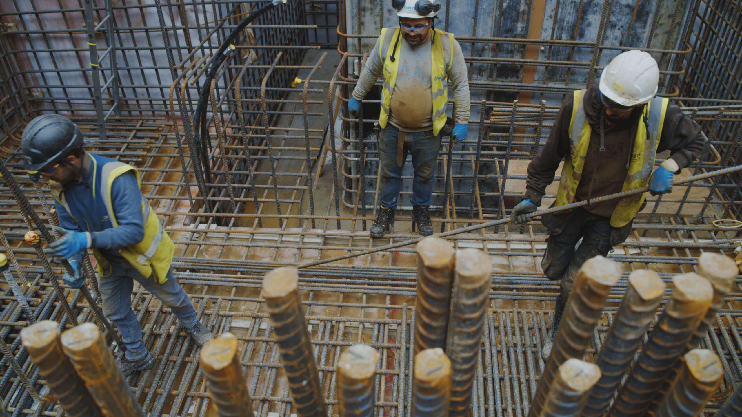 Construction workers installing steel reinforcement bars on site