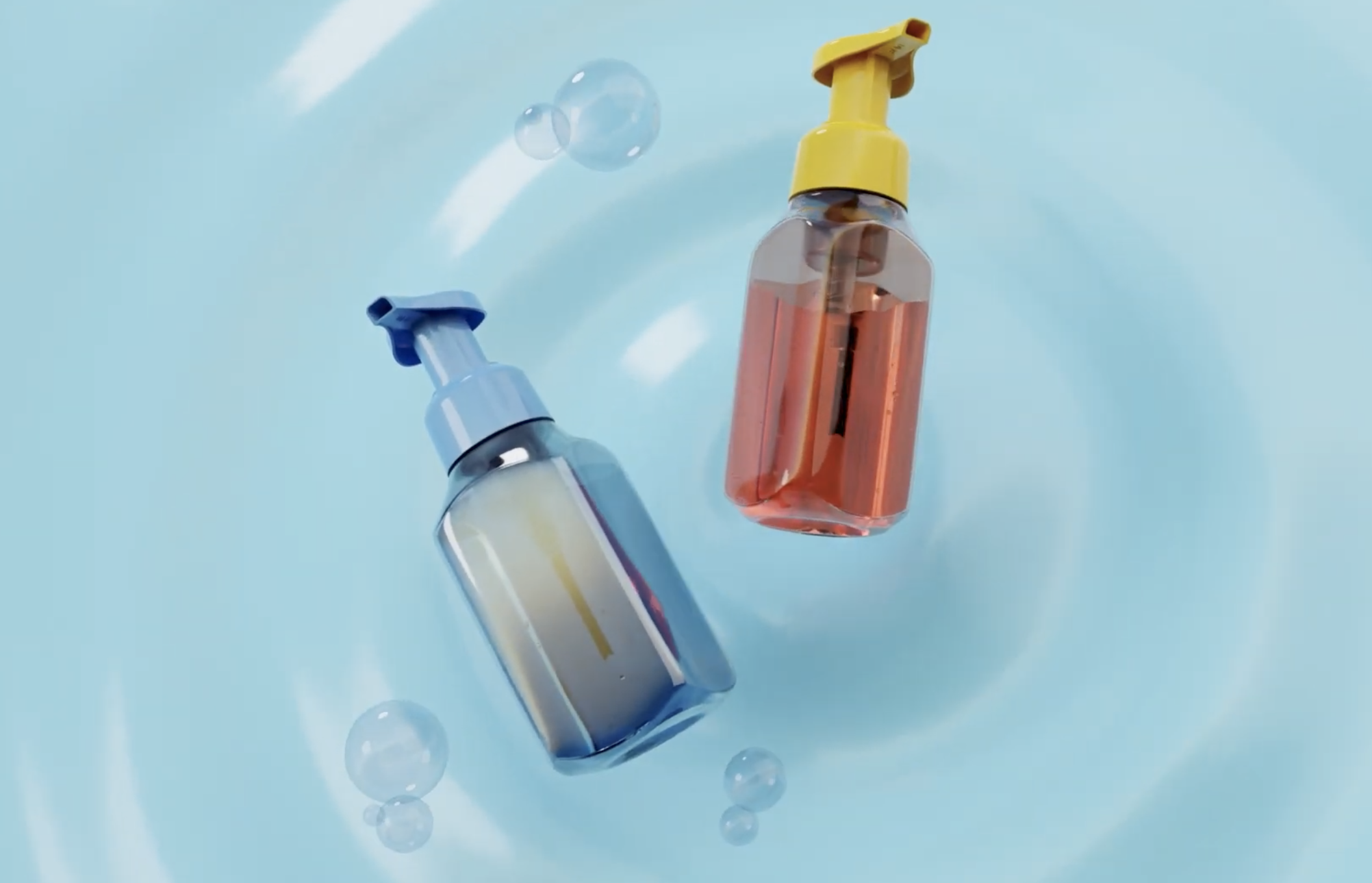 Two soap dispensers with blue and yellow pumps floating in water with bubbles