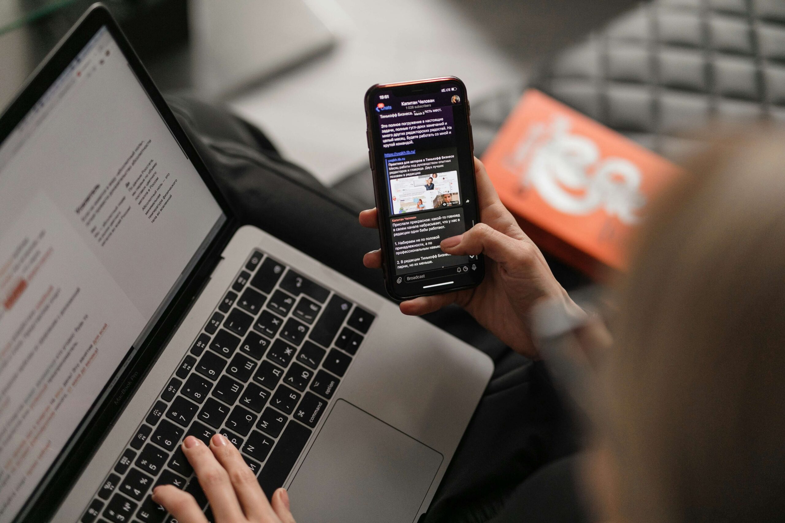 Person using a smartphone and laptop for email marketing tasks